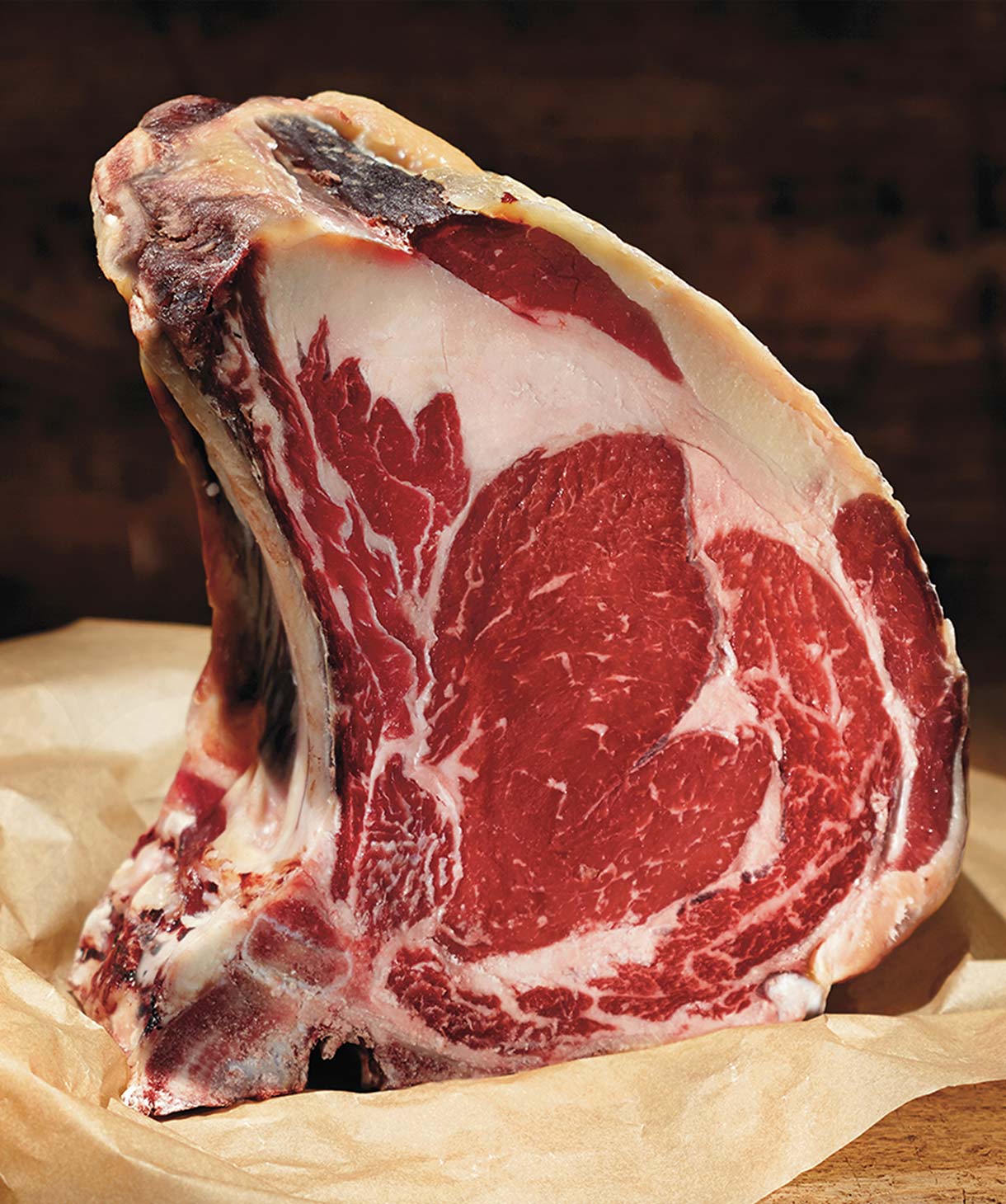 Nahaufnahme eines Steaks von vorne, das auf einem Holzbrett präsentiert wird.