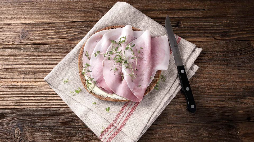 Bauernbrot mit Kochschinken, appetitlich auf einem Tuch präsentiert.