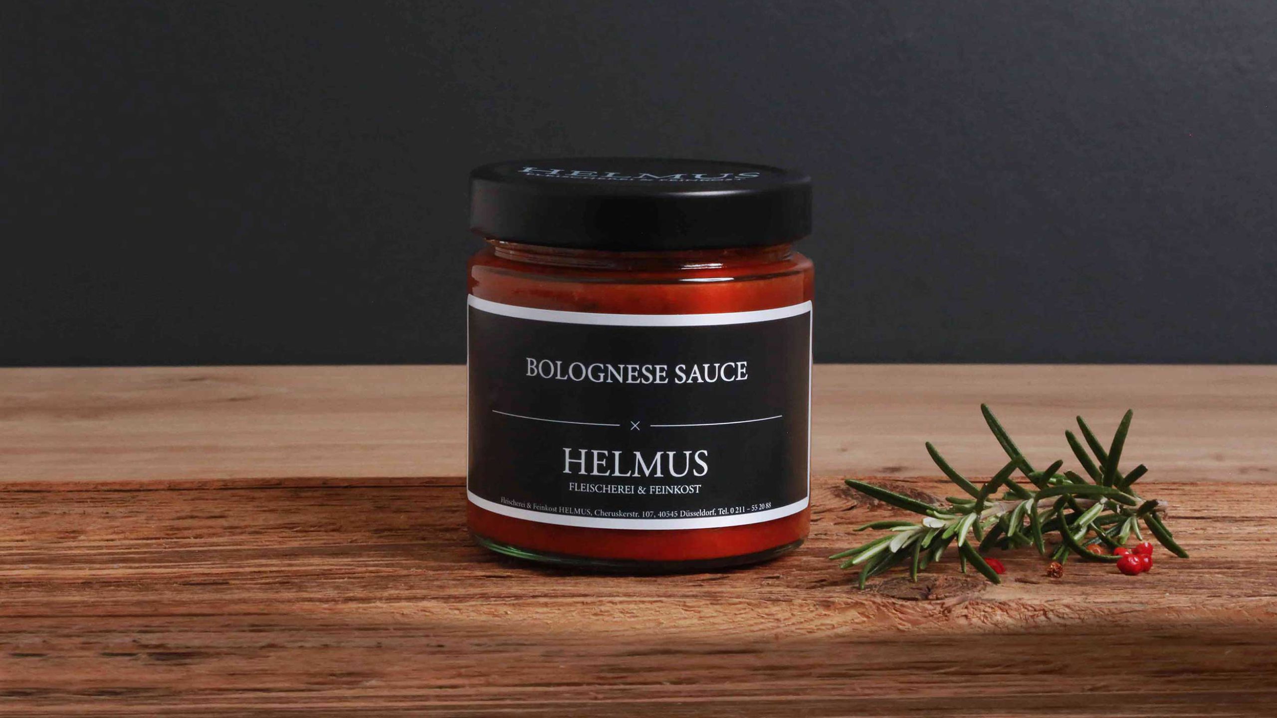Glas mit Bolognese-Sauce, platziert auf einem natürlichen Holzuntergrund.