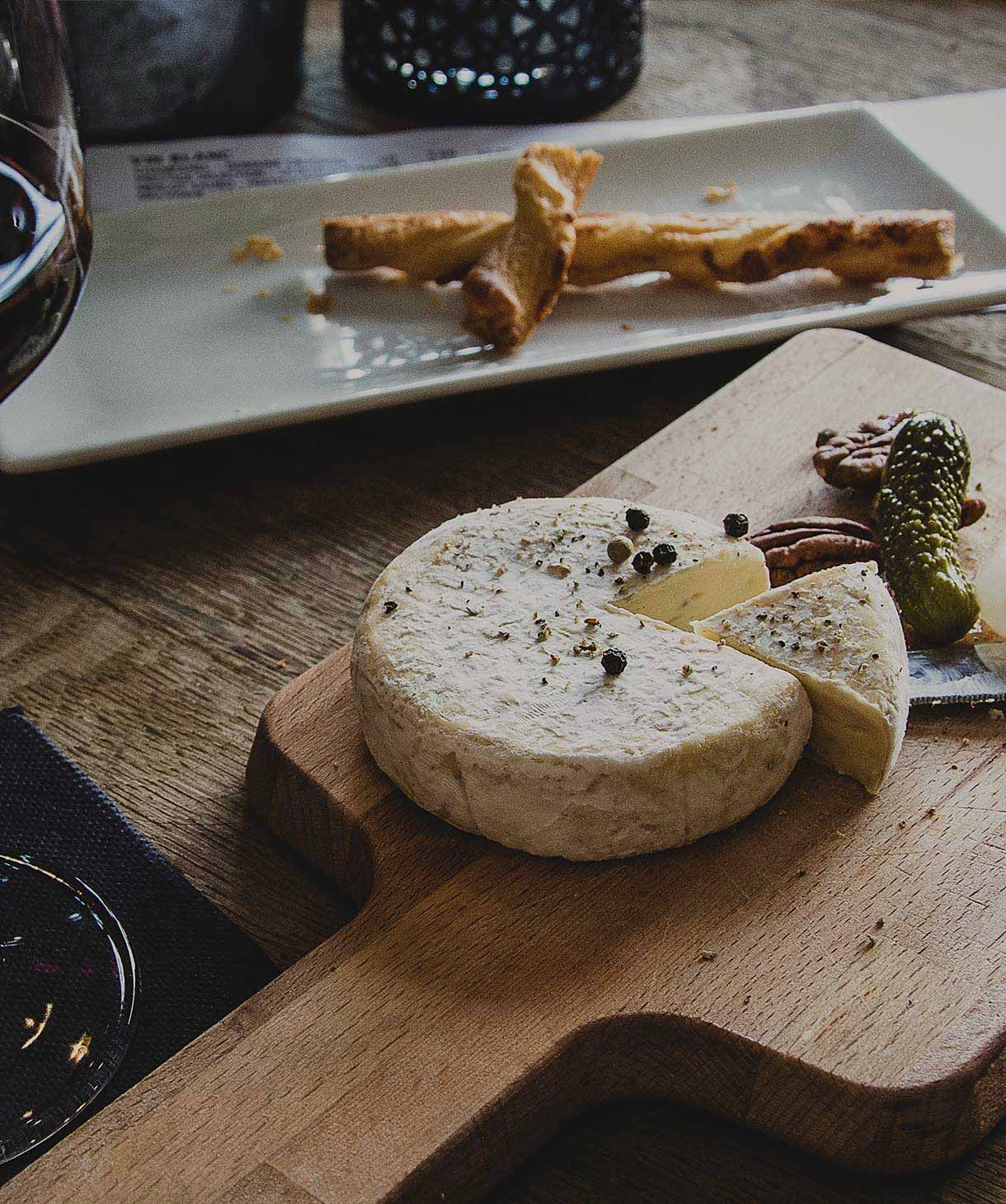 Produktaufnahme von Käse auf einem Holzbrett, das die Textur und Farbe des Käses gut zur Geltung bringt. 