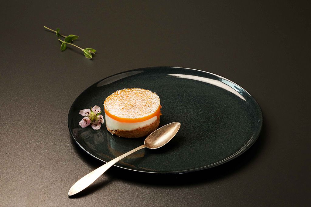 Sable-Mango-Kokos auf einem Teller, geschmückt mit einer Blütespitze.