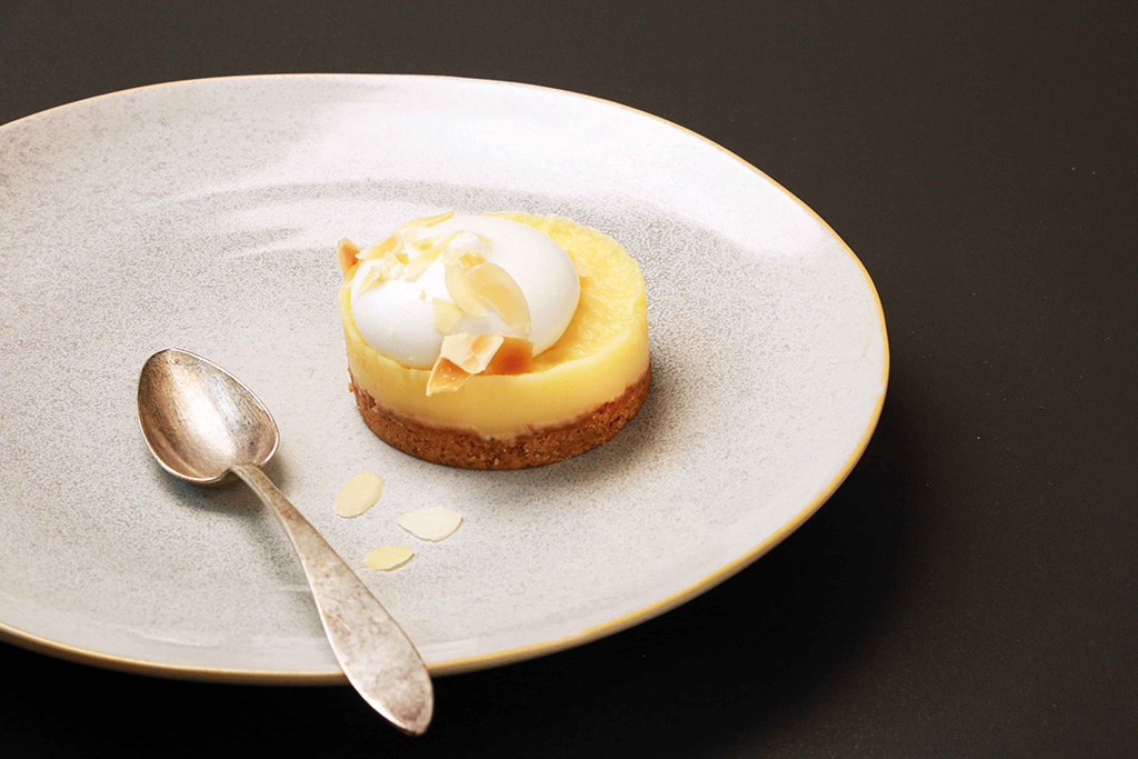 Sable-Zitron auf einem Teller, daneben ein Löffel, präsentiert in einer eleganten Anordnung.