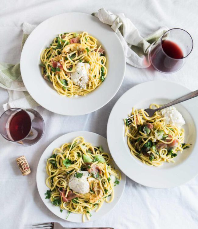Ansicht von oben auf einen Tisch mit Pastatellern und Weingläsern, dekorativ angerichtet für ein leckeres Essen.